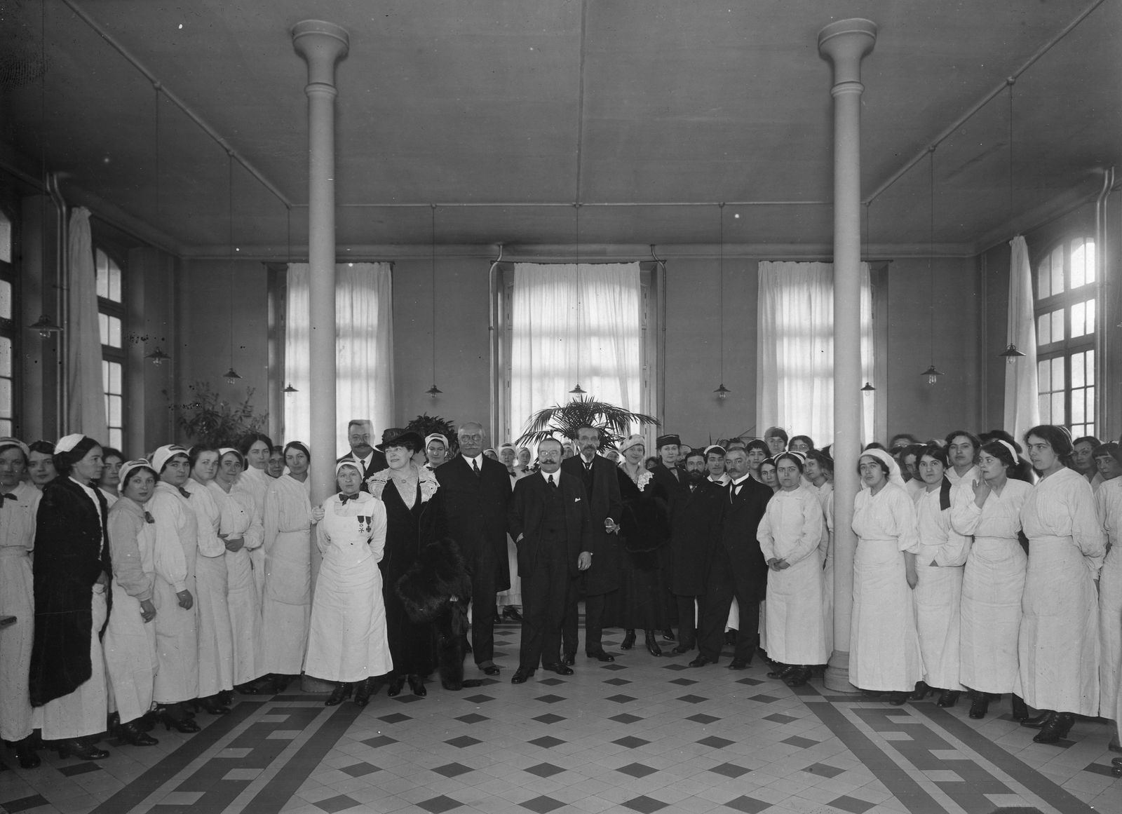 Les élèves infirmières de l'hospice de la Salpêtrière entourant Gustave Mesureur, directeur de l’Assistance publique, 1916.