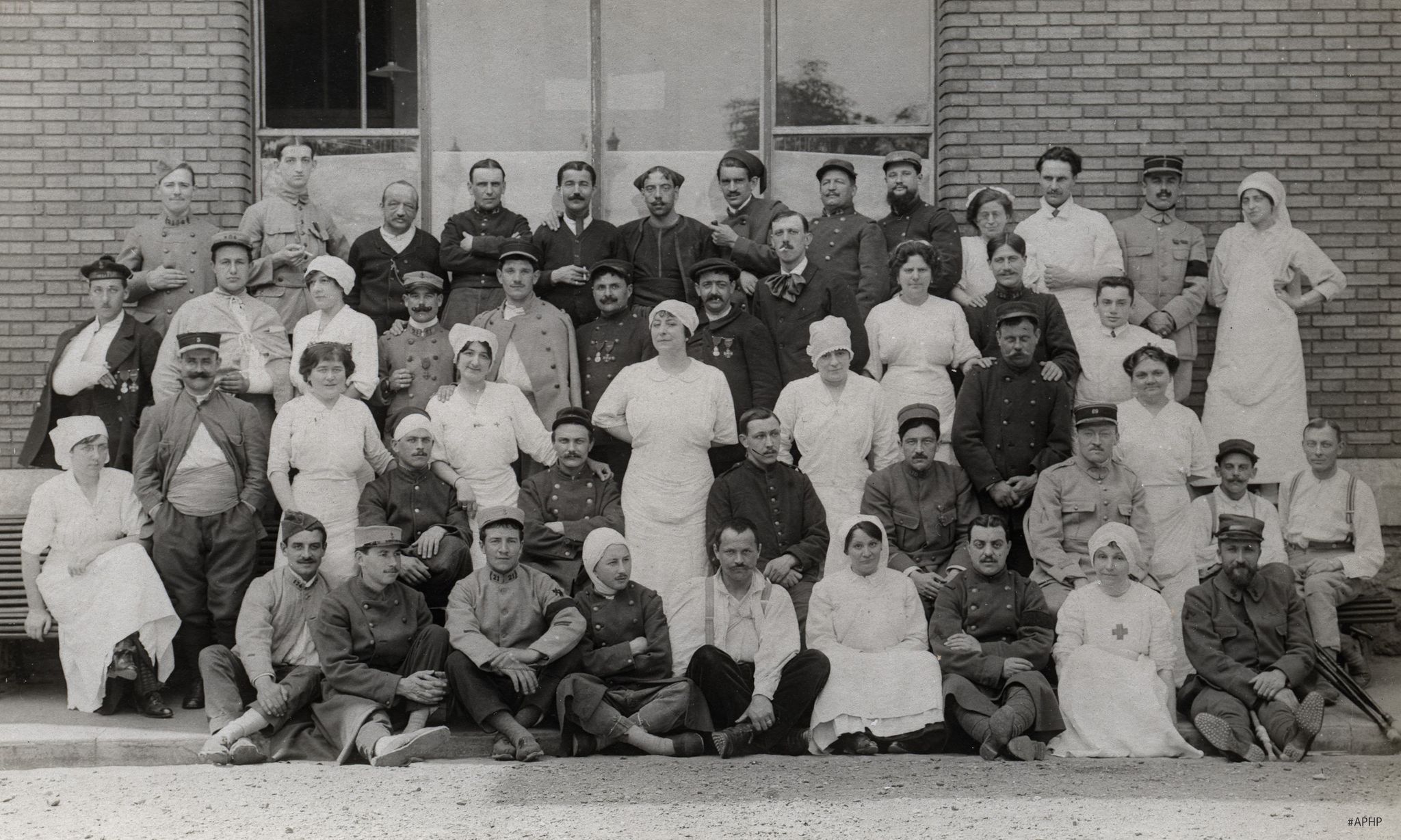 Groupe d'infirmières et de soldats posant à l'extérieur de la Pitié, 1914-1918 (Archives AP-HP, 28Z/7).