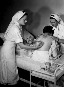 Elèves infirmières avec une patiente lors de la pose de ventouses, juin 1952.